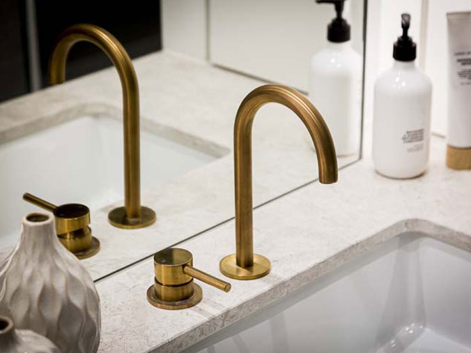 Sink with brass gooseneck faucet and soap dispensor