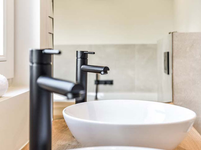 Dual bathroom basin sinks with black faucets and hardware